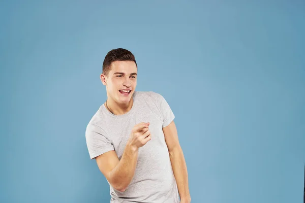 Homme gai dans un t-shirt blanc gesticulant avec ses mains émotions fond bleu — Photo