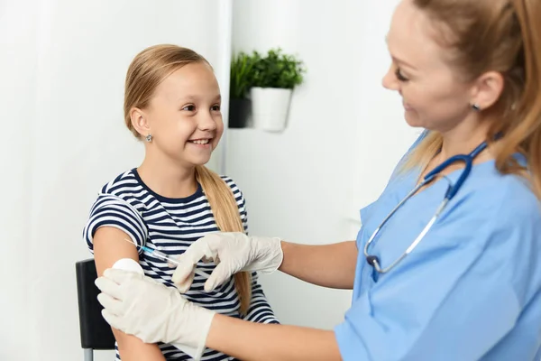 Kvinna läkare injektioner i armen på ett barn på sjukhuset hälsovård covid vaccination — Stockfoto