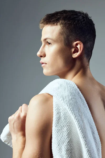 Красивый парень с полотенцем на спине на сером фоне — стоковое фото