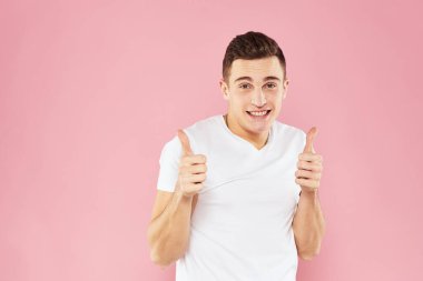 Beyaz tişörtlü neşeli yakışıklı adam duygular pembe soyutlanmış arka plan