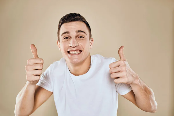 Cute emotional man white t-shirt gesture with hands cropped view beige studio background — Stock Photo, Image