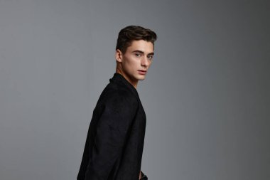 Yakışıklı siyah ceketli çekici bir adam. Moda tarzı bir stüdyo.