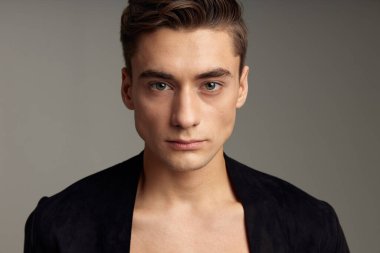 Yakışıklı, modaya uygun, siyah ceketli, yakın çekim çekici bir genç.