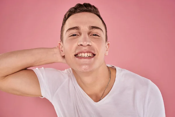 Vrolijk man in wit t-shirt glimlach emoties close-up roze achtergrond studio — Stockfoto