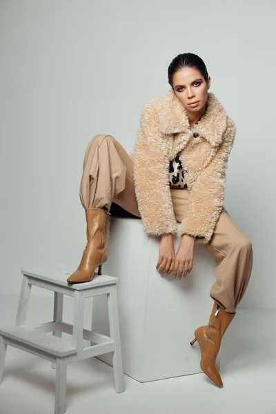 Kvinna på modet höst kläder poserar sittande bruna skor — Stockfoto