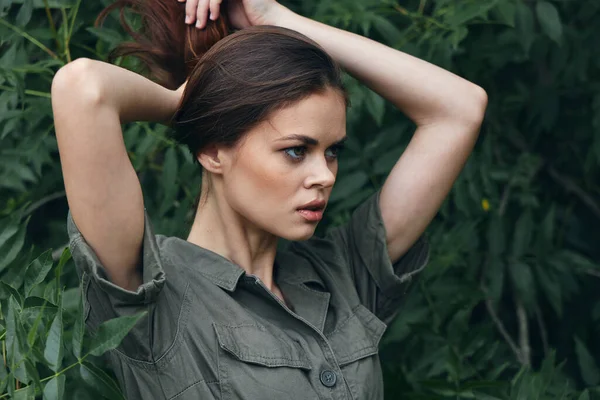 Vrouw buiten groen shirt met zakken en natuur bladeren — Stockfoto