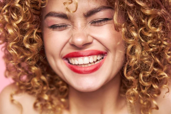 Mooie vrouw glimlach rode lippen gesloten ogen krullend haar close-up helder make-up — Stockfoto
