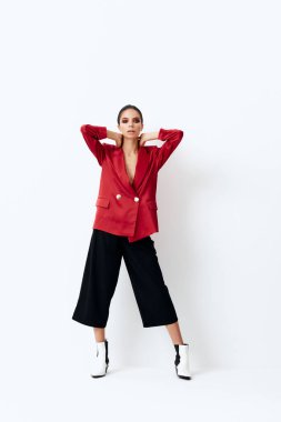 Yüzünde parlak makyajlı esmer, şık giyimli elleri kafasının arkasında poz veren.