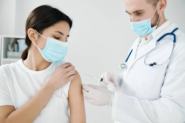 Medico in abito medico e una donna in maschera protettiva covid-19 vaccinazione — Foto Stock