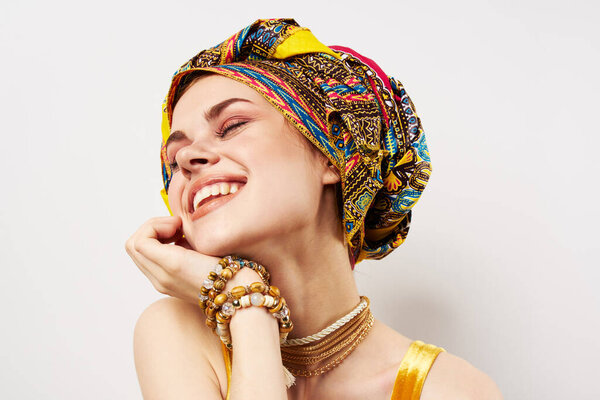 Emotional cheerful woman with a turban on her head traditional clothing studio close-up. High quality photo