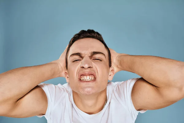 Man gebaart met zijn handen emoties wit t-shirt expressie blauw achtergrond — Stockfoto