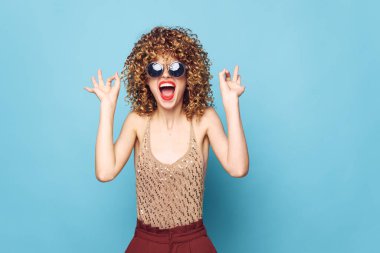 Dudakları açık, kırmızı dudakları jestlerle neşeli parlak makyajlar yapıyor. 