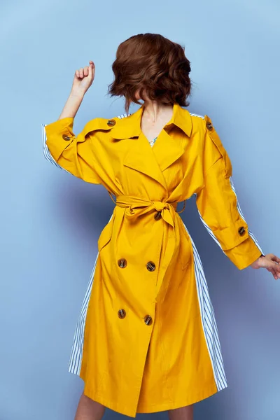 Mulher casaco amarelo olhar de lado penteado elegante maquiagem brilhante — Fotografia de Stock