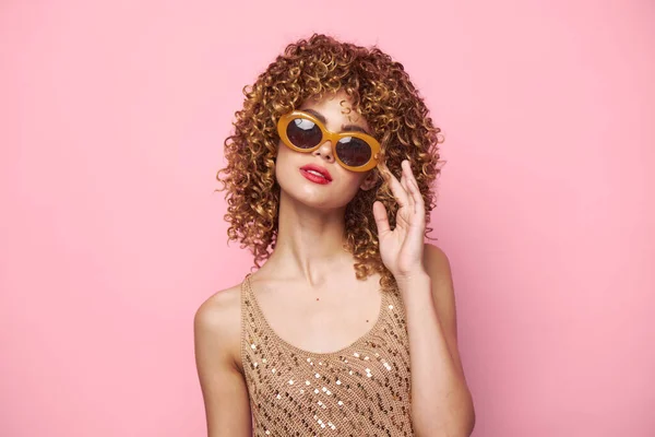 Σέξι μοντέλο μπούκλες σκούρα γυαλιά κόκκινα χείλη ελκυστική ματιά ροζ φόντο φωτεινό μακιγιάζ — Φωτογραφία Αρχείου