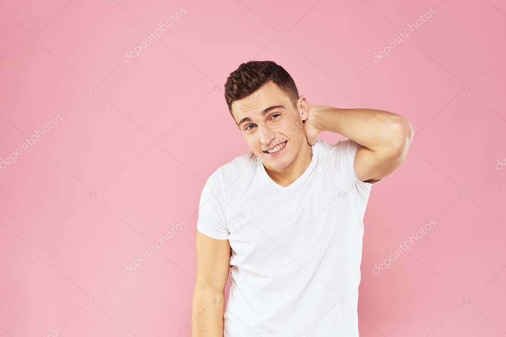 Cheerful handsome man in white t-shirt emotions pink isolated background