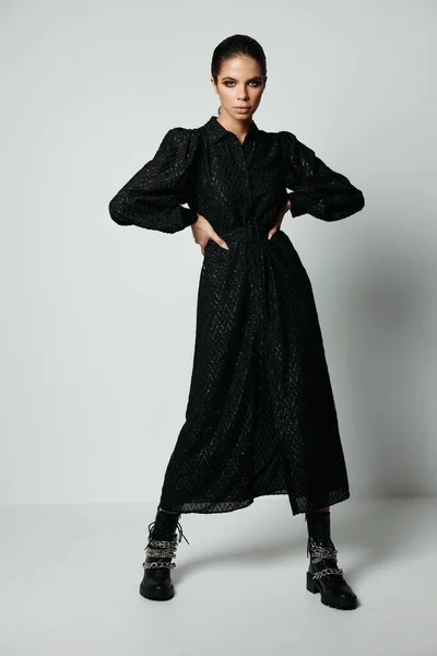 검은 드레스를 입은 예쁜 갈색 갈색 머리의 여성 벨트 패션에 손을 잡고 — 스톡 사진