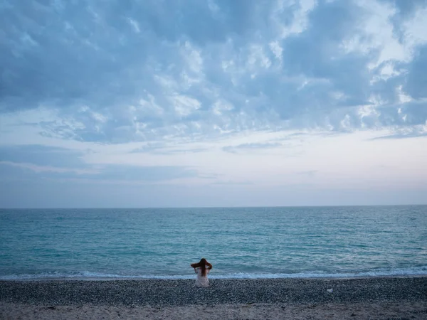 Mujer viajero por el océano en la playa y el mar en las nubes de fondo — Foto de Stock