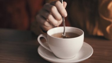 Çay masasında beyaz bardakta sıcak bir içecek.