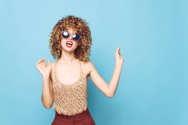 Seksi model kıvırcık saçlı gülücük güneş gözlüğü arka plan model kırmızı pantolon.