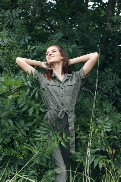 Donna nella foresta a riposo nella natura e tenendo le mani dietro la testa, alberi tuta — Foto Stock