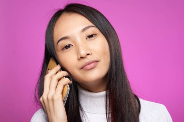 Elinde telefon olan güzel bir kadın internet teknolojisi mesajları pembe arka plan