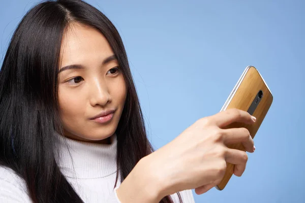 Mujer de asiático apariencia con un teléfono en manos comunicación internet tecnología — Foto de Stock