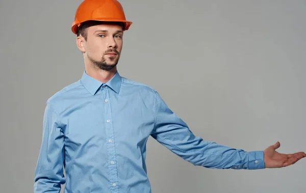 オレンジ色の塗料とグレーの背景の肖像画に青いシャツの男性建築家 — ストック写真