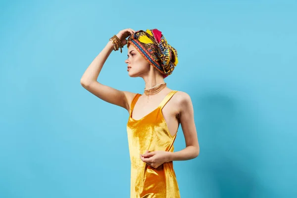 Γυναίκα με κίτρινο φόρεμα πολύχρωμο τουρμπάνι στο κεφάλι διακόσμηση στούντιο lifestyle αίγλη — Φωτογραφία Αρχείου