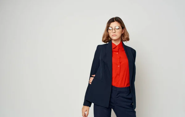 Mujer de negocios en un traje azul clásico y una camisa roja gestos Copiar espacio — Foto de Stock