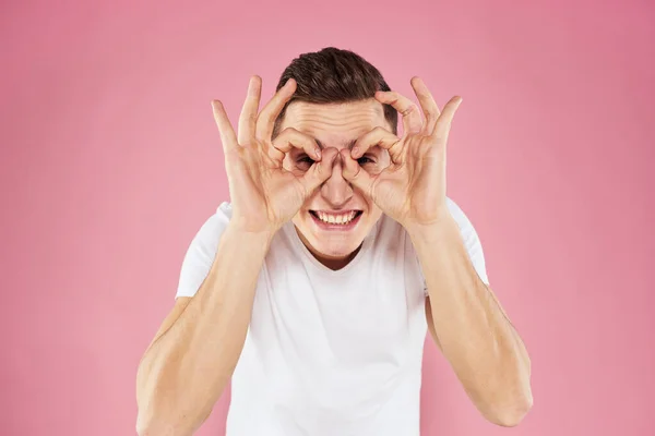 手の感情を持つ白いTシャツのジェスチャーで男ピンクの背景スタジオクロップドビュー — ストック写真