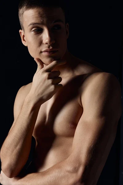 Retrato de um atleta em um fundo escuro músculos de treinamento modelo corte vista — Fotografia de Stock