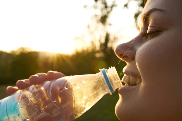 Nő iszik vizet egy műanyag palack szabadban nyáron — Stock Fotó
