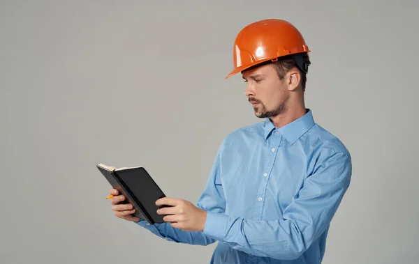 Civil engineer in orange hard hat holding documents in hands notepad business work — Stock Photo, Image