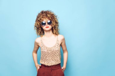 Güzel, kıvırcık saçlı, zarif kırmızı dudaklı güneş gözlüğü stüdyosu. 