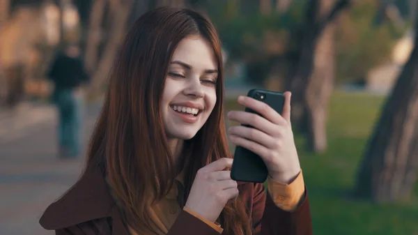 Mujer al aire libre en el parque se comunica por teléfono caminar emociones — Foto de Stock