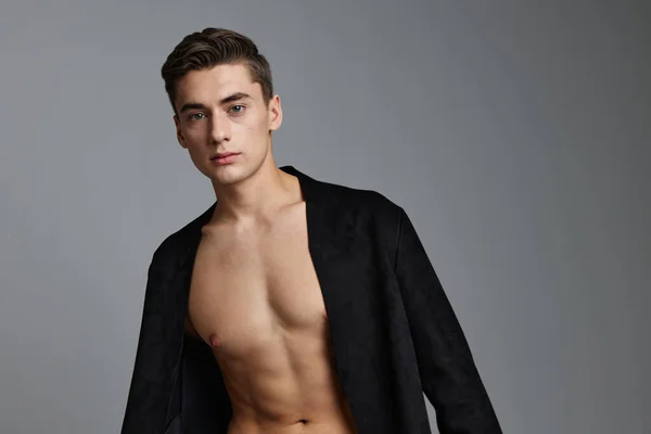 Hombre en chaqueta negra torso desnudo aspecto atractivo posando confianza en sí mismo — Foto de Stock