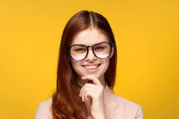 Glimlachende vrouw met bril glamour gezicht mouwen gele achtergrond luxe — Stockfoto