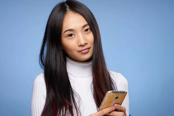 Женщина азиатский внешний вид телефон руки коммуникационные технологии образ жизни синий фон — стоковое фото