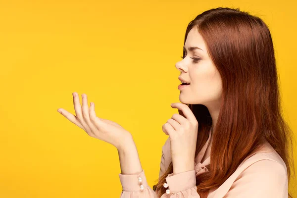 Bella donna gesticolando con le mani su sfondo giallo fascino — Foto Stock