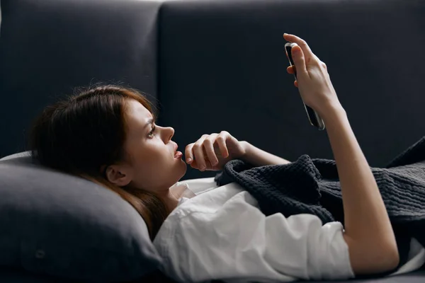 Retrato de mulher bonita com telefone celular no sofá vista cortada — Fotografia de Stock