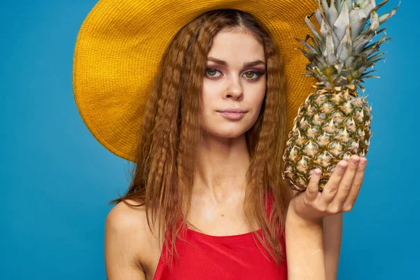 Mulher de chapéu amarelo com abacaxi nas mãos emoções divertido estilo de vida verão fruta azul fundo — Fotografia de Stock