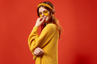 Gözlüklü, sarı süveter giyen güzel bir kadın.