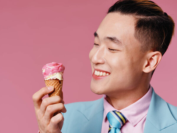 Happy guy in a classic suit and ice cream in a cone pink background — Stock Photo, Image