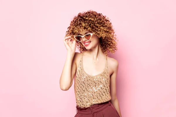 Красива жінка Кучеряве волосся сонцезахисні окуляри посміхаються рожевий фон — стокове фото