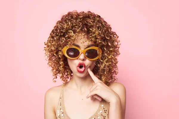 Модель Кучеряве волосся похмурі темні сонцезахисні окуляри рожевий фон модний одяг — стокове фото