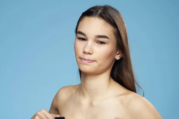 Brunett med bara axlar kosmetika närbild hudvård blå bakgrund — Stockfoto