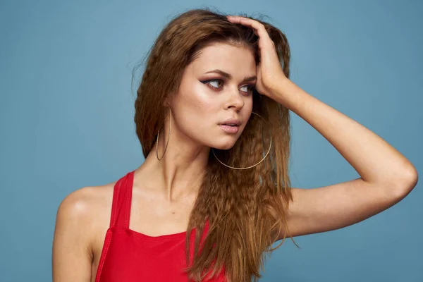 Femme avec les cheveux ondulés look attrayant débardeur rouge fond bleu — Photo