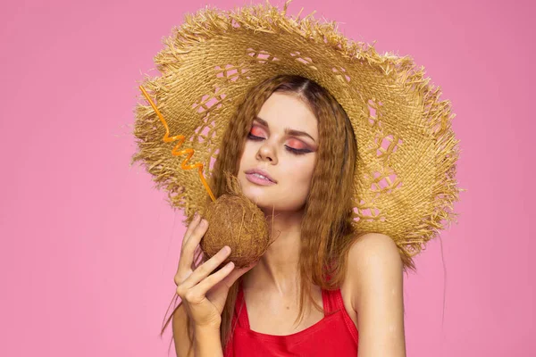 Kvinna med kokos cocktail i halm hatt exotisk semester sommar rosa bakgrund — Stockfoto