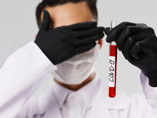 Чоловічий лабораторний асистент покриває обличчя руками дослідження аналізу крові — стокове фото