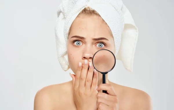 Modell kvinna med förstoringsglas på ljus bakgrund och handduk på huvudet — Stockfoto